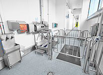 Staff hygiene station with drive-through disinfection basin within a material sluice 